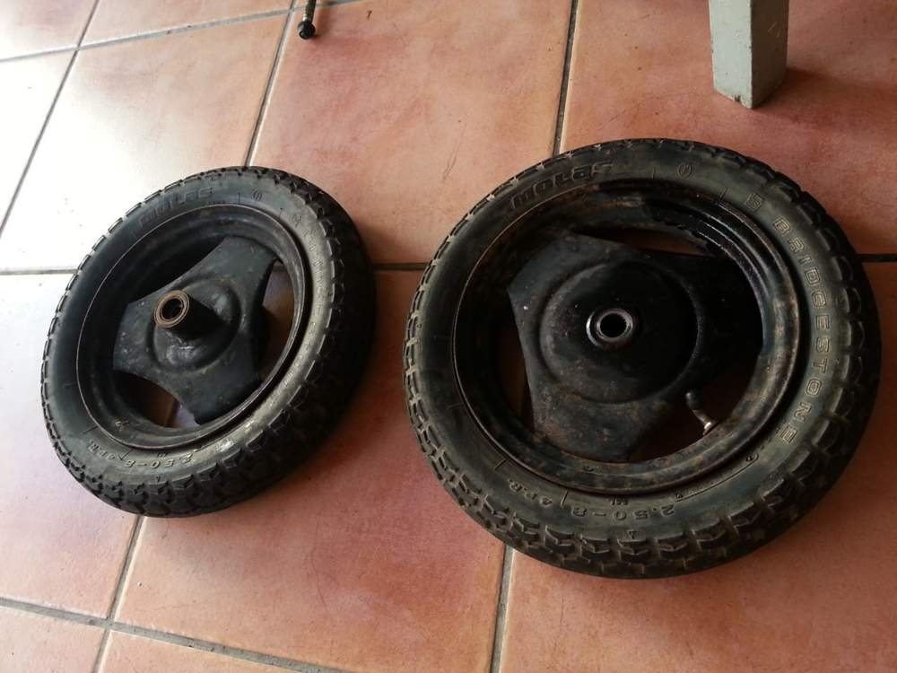 Ruedas originales de la Honda Motocompo antes de restaurar, con cubiertas antiguas y llantas marcadas.